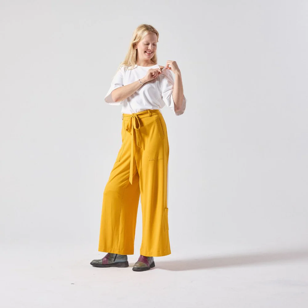 Woman wears bright wide leg trousers with front belt bow